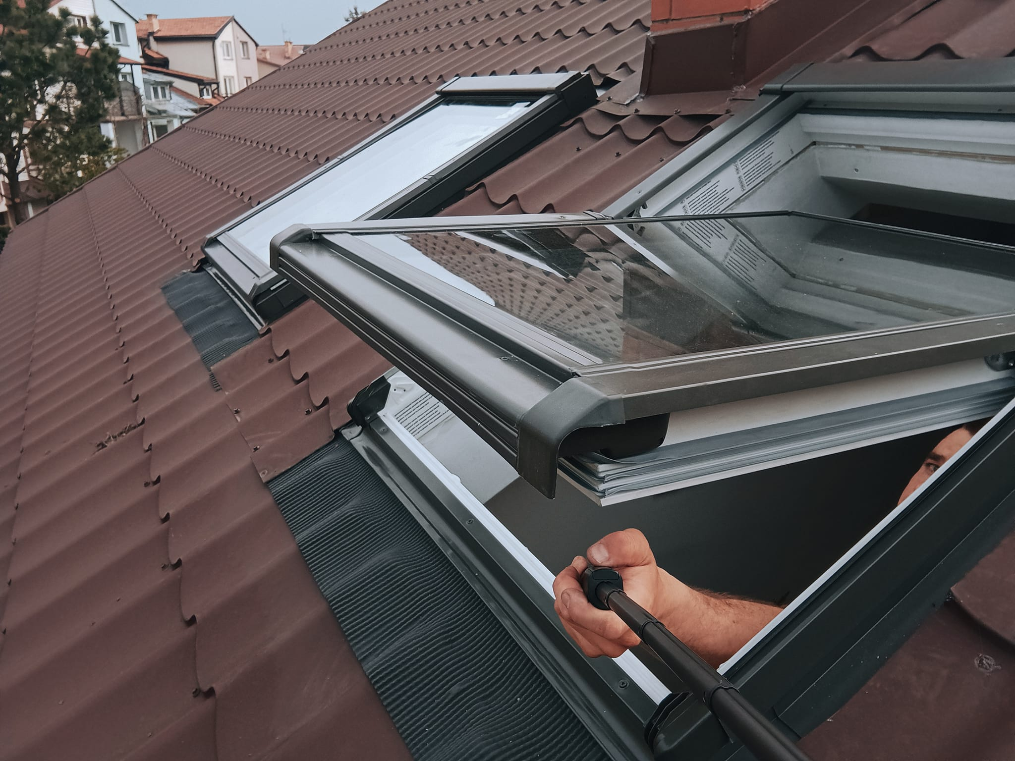 Nowe okno dachowe zamontowane na dachu domu jednorodzinnego